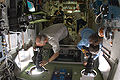 Jeffrey Williams and Nicole Stott, Expedition 21, use cameras at windows