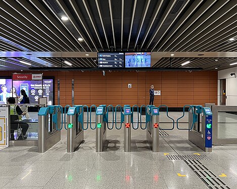 Fare gates at Stevens MRT station in Singapore, including a wider gate for priority users